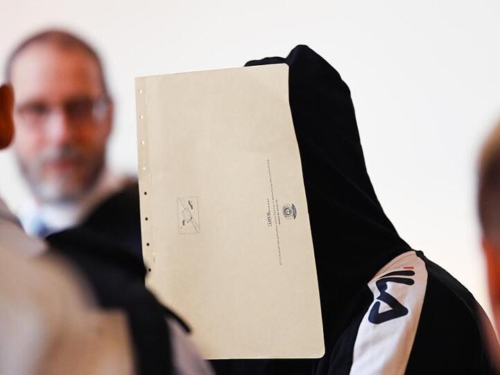 Einer von elf Angeklagten sitzt in einen Gerichtssaal im Landgericht Freiburg.