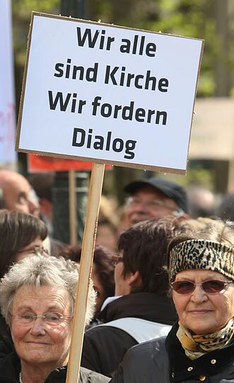 Katholiken stehen am Samstag (21.04.2012) mit Transparenten auf dem Domplatz von Augsburg (Schwaben). Im Rahmen einer Kundgebung demonstrieren sie gegen die geplante Pastoralreform des Bistums Augsburg.