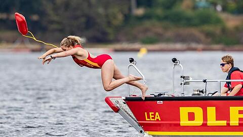 Eine Rettungsschwimmerin der DLRG springt während einer Übung in einen See. Foto: Marcel Kusch/dpa/Symbolbild