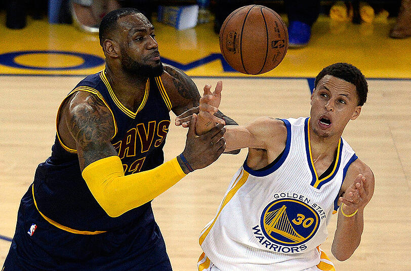 Warriors-Guard Stephen Curry (rechts) schnappt Cavaliers-Forward LeBron James den Ball weg.
