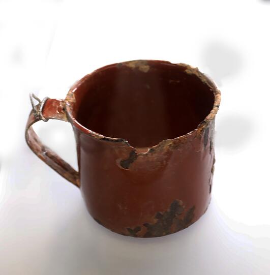Ein Becher aus Emaille.