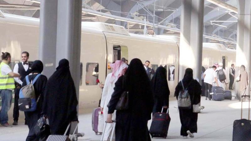 Saudische Frauen mit Ganzkörperschleier ziehen ihre Rollkoffer über einen Bahnsteig in Medina. Saudische Frauen mit Ganzkörperschleier ziehen ihre Rollkoffer über einen Bahnsteig in Medina.