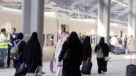 Saudische Frauen mit Ganzkörperschleier ziehen ihre Rollkoffer über einen Bahnsteig in Medina.