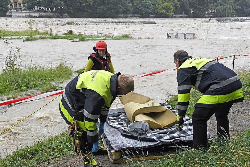 Einsatzkräfte der Wasserrettung bergen Habseligkeiten aus dem Obdachlosenlager unter der Reichenbachbrücke.