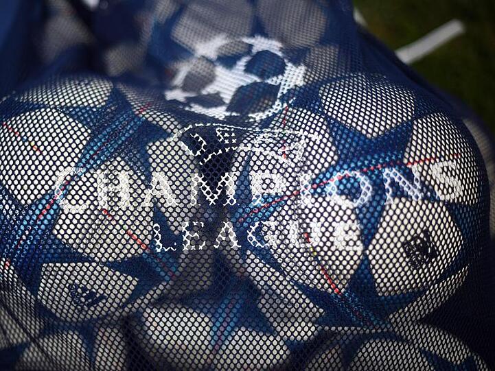 Bälle mit dem Logo der UEFA Champions League liegen in einem Netz.