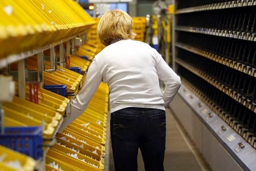 Post-Mitarbeiterin beim Sortieren: Frauen verdienten im Schnitt fast ein Viertel weniger als Männer.