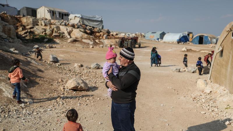 Ein Mann steht mit seinen Kindern in einem Flüchtlingslager in der Provinz Idlib.