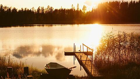 Der Sonnenuntergang &uuml;ber einem finnischen See.
