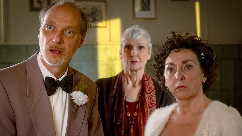 "Mit Herz und Hilde": Als Hilde (Steffi Kühnert, r.) und Ronnie (Martin Brambach, l.) vor der Pastorin (Ulrike Hübschmann) ihr Ehegelübde erneuern wollen, tauchen überraschend zwei fremde Gäste auf.