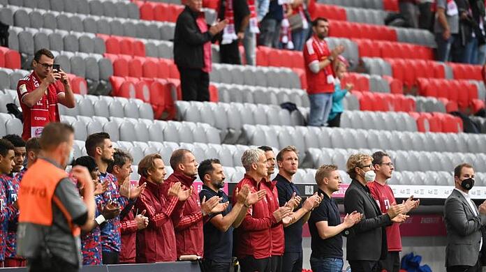 Die Trainerbank applaudiert nach einer Schweigeminute für den verstorbenen Gerd Müller.
