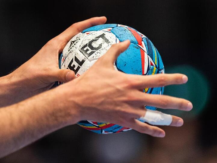 Ein Ball ist in der Hand eines Spielers zu sehen. Foto: Robert Michael/dpa/Symbolbild