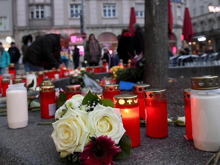 Kerzen und Blumen zum Gedenken an den getöteten Feuerwehrmann am Augsburger Königsplatz. Foto: Stefan Puchner/dpa