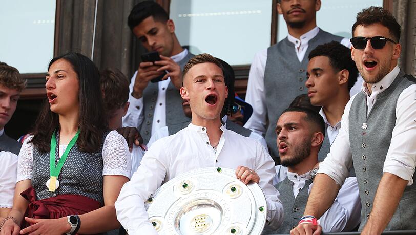 Bayerns Joshua Kimmich (M) jubelt mit der Meisterschale auf dem Rathaus-Balkon.