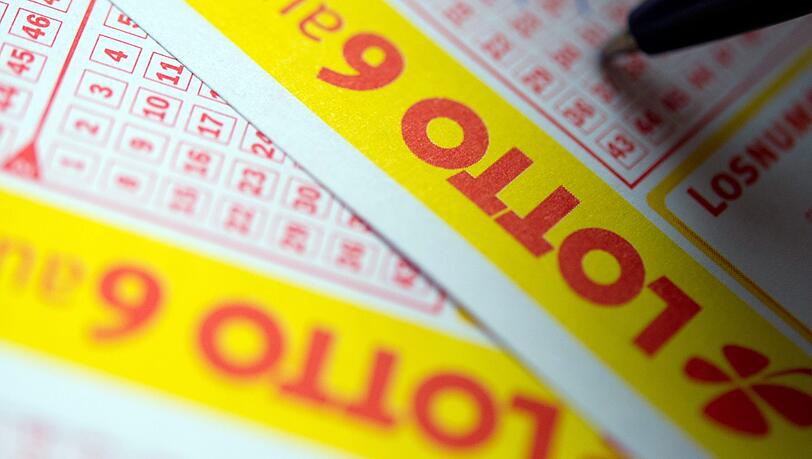 Ein Mann füllt einen Lottoschein aus. Ein Mann füllt einen Lottoschein aus.