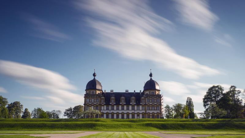 Wolken ziehen über das Schloss Seehof hinweg. Foto: Nicolas Armer/dpa/Symbolbild