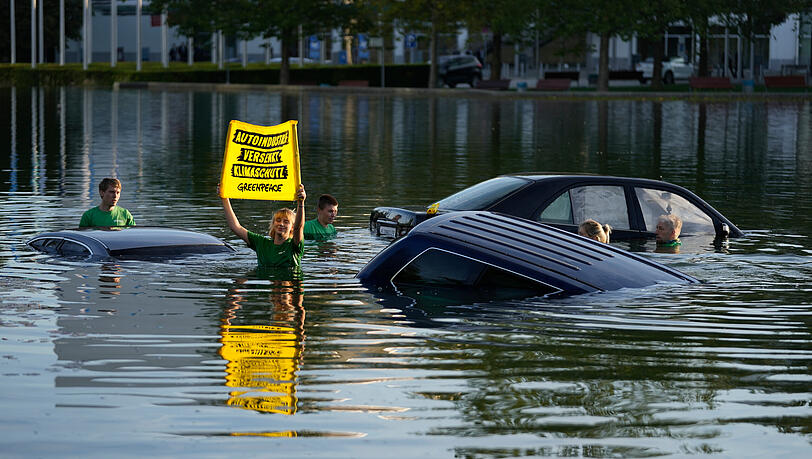 Umweltaktivisten von Greenpeace demonstrieren am Pressetag bei der Auto- und Verkehrsmesse IAA in der Messe München im See vor dem Haupteingang. Umweltaktivisten von Greenpeace demonstrieren am Pressetag bei der Auto- und Verkehrsmesse IAA in der Messe München im See vor dem Haupteingang.