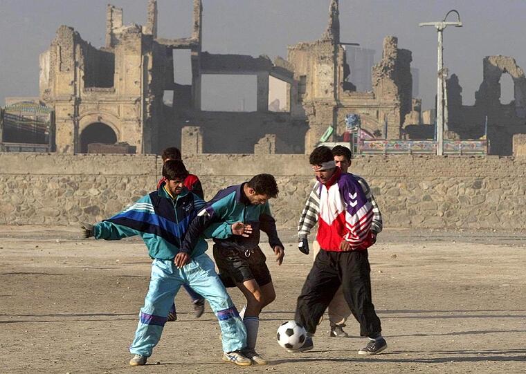 Fußballspielen auf den Trümmern des zerstörten Stadions von Kabul.
