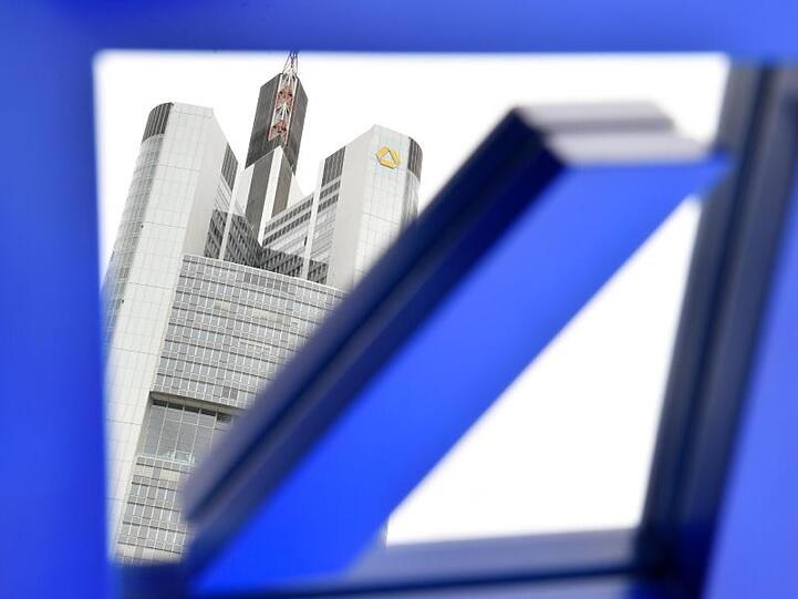 In einem Spiegel mit dem Logo der Deutschen Bank ist in Frankfurt die Zentrale der Commerzbank zu sehen.