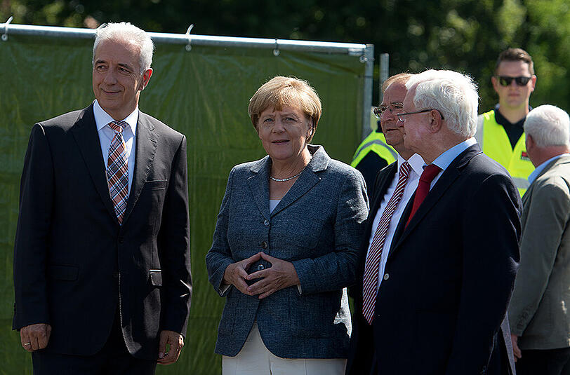 Bundeskanzlerin Angela Merkel wird an der Flüchtlingsunterkunft in Heidenau von dem DRK Präsidenten Rudolf Seiters (r), dem Ministerpräsidenten von Sachsen Stanislaw Tillich (l) und dem Bürgermeister von Heidenau Jürgen Opitz (3.v.l.) begrüßt.