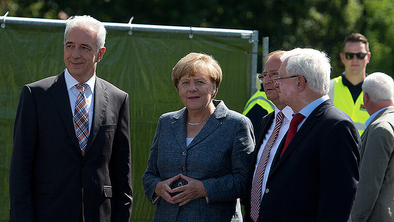 Bundeskanzlerin Angela Merkel wird an der Flüchtlingsunterkunft in Heidenau von dem DRK Präsidenten Rudolf Seiters (r), dem Ministerpräsidenten von Sachsen Stanislaw Tillich (l) und dem Bürgermeister von Heidenau Jürgen Opitz (3.v.l.) begrüßt. Bundeskanzlerin Angela Merkel wird an der Flüchtlingsunterkunft in Heidenau von dem DRK Präsidenten Rudolf Seiters (r), dem Ministerpräsidenten von Sachsen Stanislaw Tillich (l) und dem Bürgermeister von Heidenau Jürgen Opitz (3.v.l.) begrüßt.