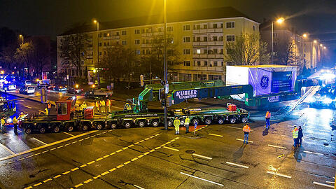 Die Turbine wird nachts quer über eine Kreuzung gefahren.