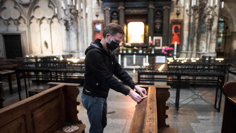 Ein Mitarbeiter der Dombauhütte klebt Aufkleber auf Kirchenbänke im Kölner Dom. Die runden Sticker sollen den Platz markieren, auf den Gottesdienstbesucher sich setzen dürfen. Ein Mitarbeiter der Dombauhütte klebt Aufkleber auf Kirchenbänke im Kölner Dom. Die runden Sticker sollen den Platz markieren, auf den Gottesdienstbesucher sich setzen dürfen.