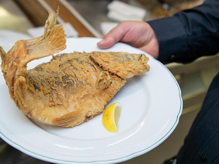 Ein frittierter Karpfen liegt auf einem Teller. Foto: Daniel Karmann/dpa