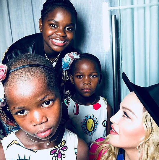 Große Familie: Für Wirbel sorgen ihre Adoptionen in Malawi. 2006 beginnt "ihr Kinder-Shopping" (so Kritiker) mit David. Es folgen Tochter Mercy (stehend) und 2017 die Zwillinge Esther und Stella.