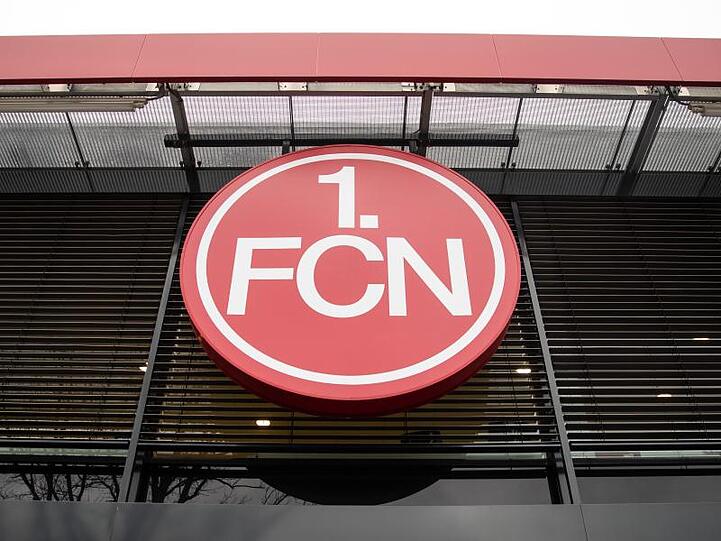 Das Logo des 1. FC Nürnberg hängt über dem Eingang der Geschäftsstelle des Vereins. Foto: Daniel Karmann/Archivbild