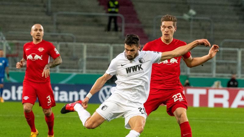 Augsburgs Daniel Caligiuri (M) und Leipzigs Marcel Halstenberg (r) in Aktion.