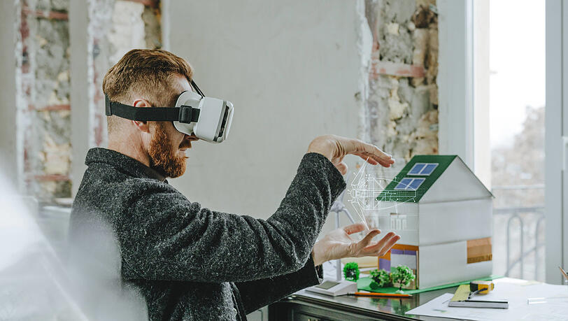 Ein Mann mit VR-Brille bei der Planung von Gebäuden. So futuristisch geht es in der Realität noch nicht zu. Expertin Laura Lammel fordert mehr Dynamik in der Digitalisierung.