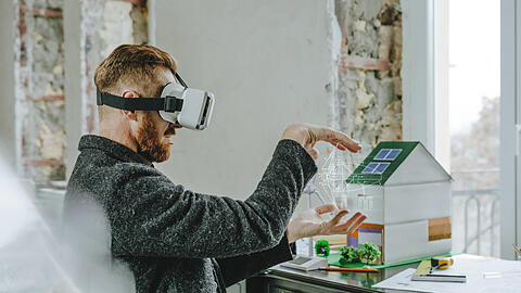 Ein Mann mit VR-Brille bei der Planung von Gebäuden. So futuristisch geht es in der Realität noch nicht zu. Expertin Laura Lammel fordert mehr Dynamik in der Digitalisierung.