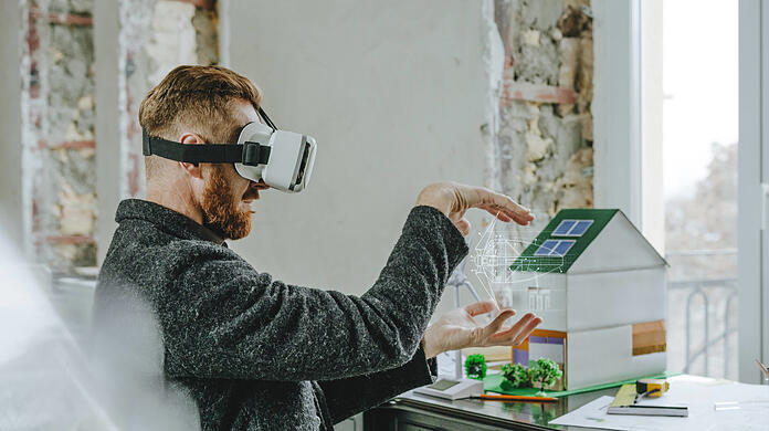 Ein Mann mit VR-Brille bei der Planung von Gebäuden. So futuristisch geht es in der Realität noch nicht zu. Expertin Laura Lammel fordert mehr Dynamik in der Digitalisierung.