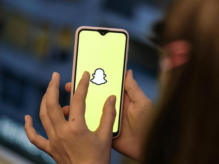 Ein Mädchen hält ihr Smartphone in den Händen. In vielen Familien ist das Smartphone ein großes Streitthema.