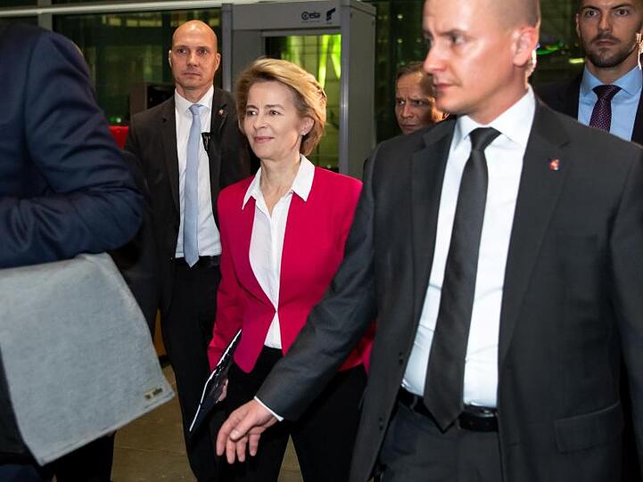 Ursula von der Leyen verlässt von zahlreichen Personenschützern begleitet den Deutschen Bundestag.
