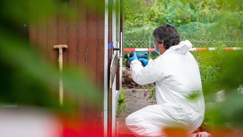 Ein Polizeibeamter der Spurensicherung kniet in der Kleingartenkolonie vor der Laube des vermutlichen Haupttäters. Ein Polizeibeamter der Spurensicherung kniet in der Kleingartenkolonie vor der Laube des vermutlichen Haupttäters.