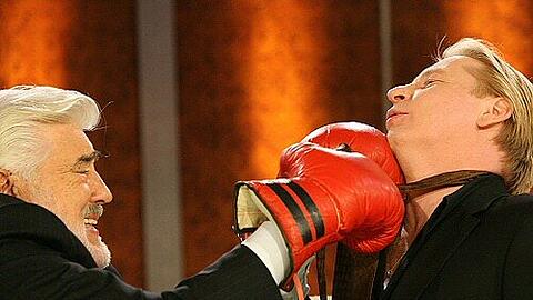 Adorf (links) und Becker binden sich die Krawatten - mit Boxhandschuhen
