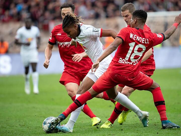 Leverkusens Baumgartlinger, Bender und Wendell (l-r) versuchen Leipzigs Christopher Nkunku vom Ball zu trennen.