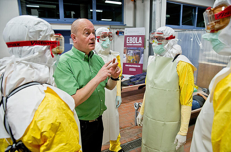 Der Anästhesie-Intensivpfleger vom Missionsärztlichen Institut, Norbert Gresser (2.v.l.), schult Seminarteilnehmer im Umgang mit Ebola-Patienten. Würzburg hat bislang das bundesweit einzige Ebola-Ausbildungszentrum neben der Bundeswehr.