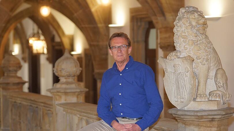 Der Chef-Hausmeister Peter Suermann sitzt auf einem Geländer im Rathaus. Es gibt hier nicht so viel zu tun wie sonst.