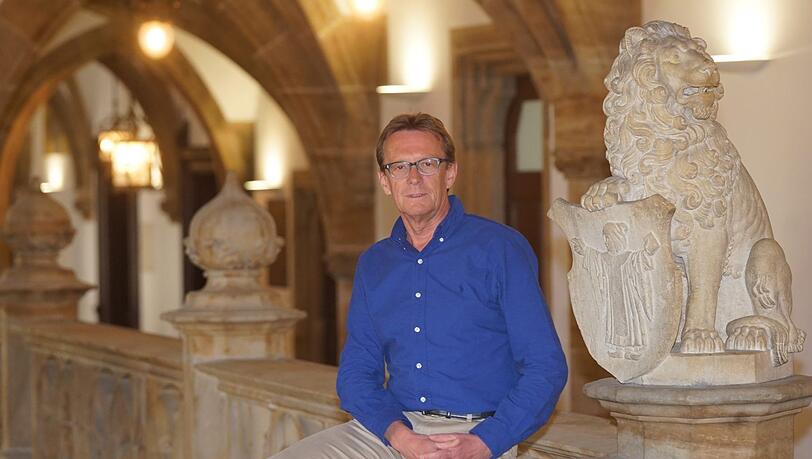 Der Chef-Hausmeister Peter Suermann sitzt auf einem Geländer im Rathaus. Es gibt hier nicht so viel zu tun wie sonst. Der Chef-Hausmeister Peter Suermann sitzt auf einem Geländer im Rathaus. Es gibt hier nicht so viel zu tun wie sonst.
