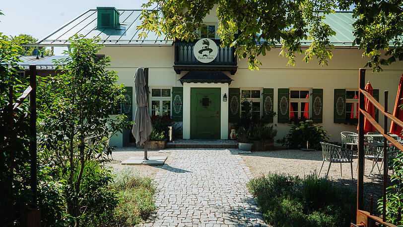 Das Wirtshaus Hans Xaver in Oberhaching. Hinten erstreckt sich der Biergarten, die Kugler Alm. Der Radlweg führt direkt zwischen Parkplatz und dem Eingang vorbei. Das Wirtshaus Hans Xaver in Oberhaching. Hinten erstreckt sich der Biergarten, die Kugler Alm. Der Radlweg führt direkt zwischen Parkplatz und dem Eingang vorbei.