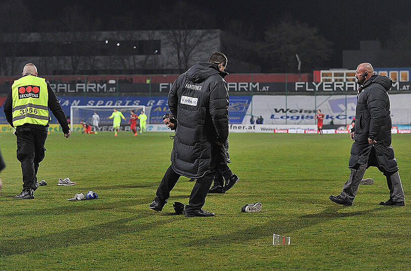 Die Fans von Austria Wien werfen ihre Schuhe auf das Spielfeld wegen zu hoher Ticketpreise.