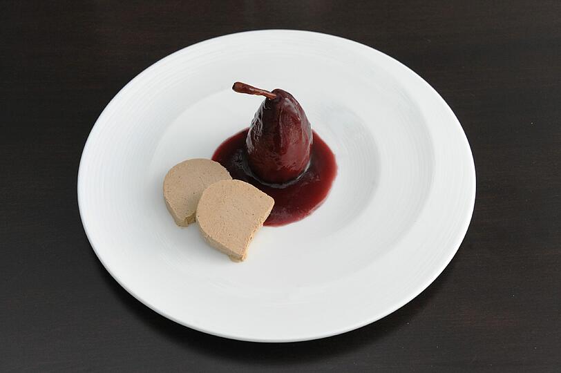 5. Gang: Moccaparfait &ndash; Rotweinbirne: Der Abschluss ist schlicht und raffiniert: Ähnlich einem Bratapfel ohne Füllung ist die Birne zubereitet, serviert wird sie mit Rotweinsauce und Moccaparfait. Das rundet ein süßer Roter mit Brombeernoten ab, der Banyuls Rimage &bdquo;Mas Cornet&ldquo;.