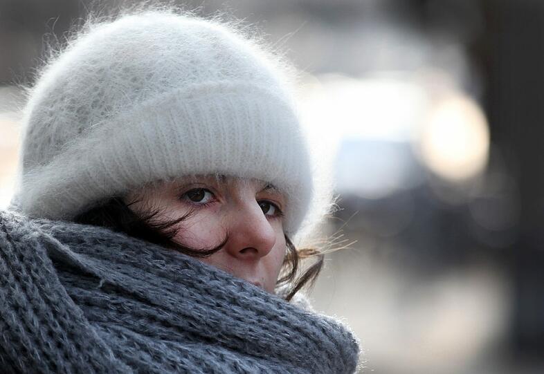 Eine kuschelige Mütze, ein warmer Schal &ndash; so schützt sich die Frau gegen die Kälte.