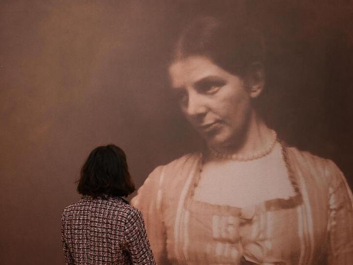 Eine Mitarbeiterin des Museums schaut sich ein Foto von Paula Modersohn-Becker, das um 1905 entstand, an.