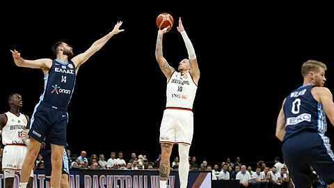 Deutschlands Daniel Theis (M) springt neben dem Griechen Giorgos Papagiannis zum Wurf hoch.