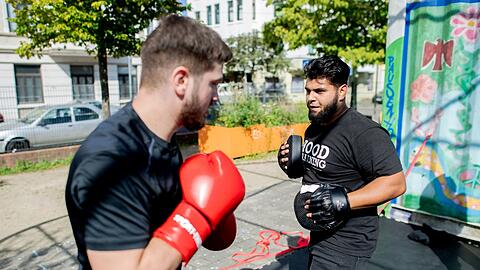Aytac Alsancak (r.), und Oguzhan Demir, beide Boxtrainer im sogenannten Hood Training, auf dem Quartiersplatz Leher Pausenhof im Stadtteil Lehe.