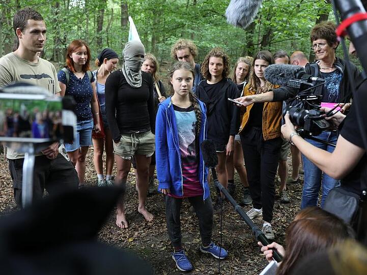 Greta Thunberg (M), Klimaschutzaktivistin, steht mit Aktivisten im Hambacher Forst.
