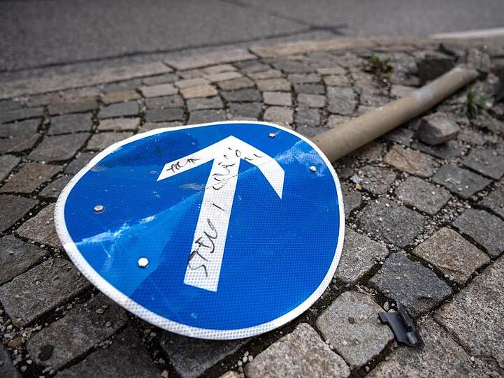 Ein beschädigtes Verkehrsschild liegt auf einer Verkehrsinsel.